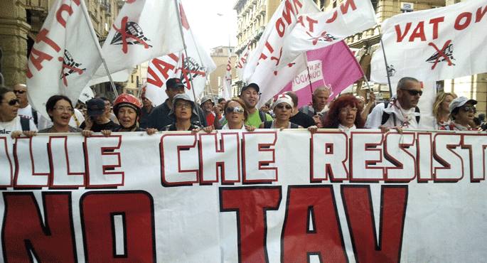 Osservatorio Represione gunetik hartutako argazkian, 2011n Italiako Turinen abiadura handiko trenaren kontra eta Val di Susa haraneko herritarren elkartasunez egindako manifestazioa. Decrescita Felice (Deshazkunde Zoriontsua) elkarteak plazaratu duen mani