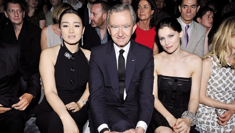 Stephan FeugÃ¨rek egindako argazkian Frantziako gizonik aberatsenetako bat, Bernard Arnault, LVMH korporazioaren Louis-Vuitton markako saltokia inauguratzen Txinako Shangain; alboan dauzka Gong Li eta Laetitia Casta aktoreak. Arnault da zerga gutxiago pag