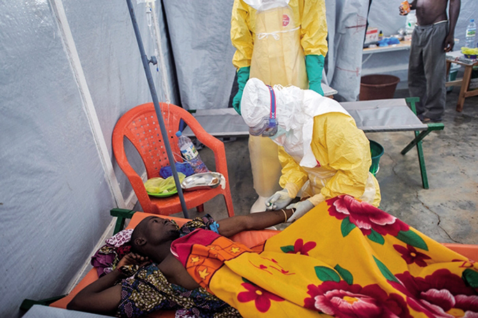 Mugarik Gabeko Medikuak (MSF) erakundeak zabaldutako argazkiak erakusten du GKE horrek Gueckedou hirian daukan artatze zentroan nola zaintzen duten Ebolak kutsatutako gaixo bat. 'Environment and Planning' zientzia aldizkarian Ebola eta olio-palmondoaren a