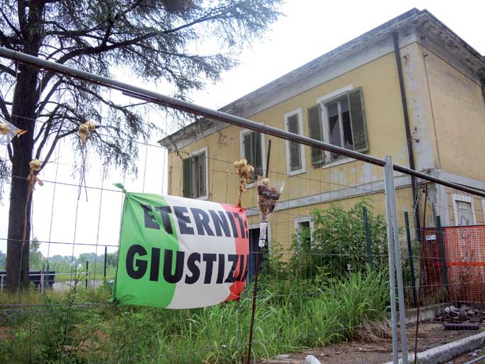 Eternit lantegiaren arrasto apur batzuk baino ez dira geratzen Casale Monferraton. Goian, herritarren borrokaren ikur bilakatu den Eternit: Giustizia leloa ageri da Italiako banderan.