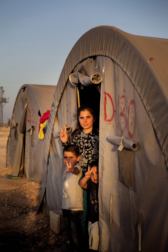 Haur babesgabeak. Rojavar asko oso gazteak dira eta senideak galdu dituzte bidean. Argazkiko neskak bi anaia txikien ardura du. Kobanê Daeshen esku erori zenean ume asko gogor torturatu zituzten Islamera ez bihurtzeagatik; neska gazte asko bahitu eta eskl