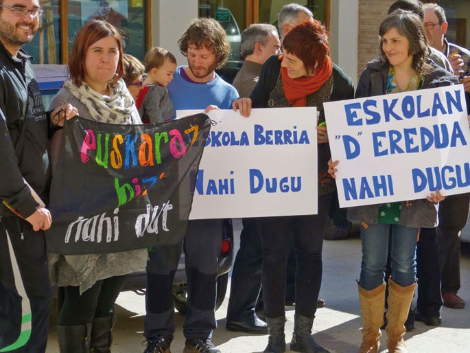 Goiko argazkian Abartzuzako eskolako haurrak eta irakaslea. Behekoa berriz, 2015eko martxokoa da. Eskolako guraso-irakasleek  D eredua eskatzeko baliatu  zuten Parlamentuko Hezkuntza komisioaren bisita.