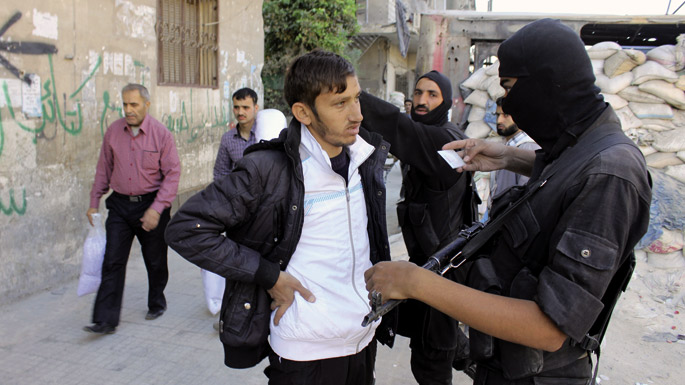 Al Nusra mugimenduko gudariak herritar baten nortasun agiria kontrolatzen Alepoko karriketan ipinitako ‘check point’ batean. Matxinoek kontrol gune ugariokin markatzen dute beren aginte sinbolikoa morrontza zor dieten herritarren eta egituren aurrean.
