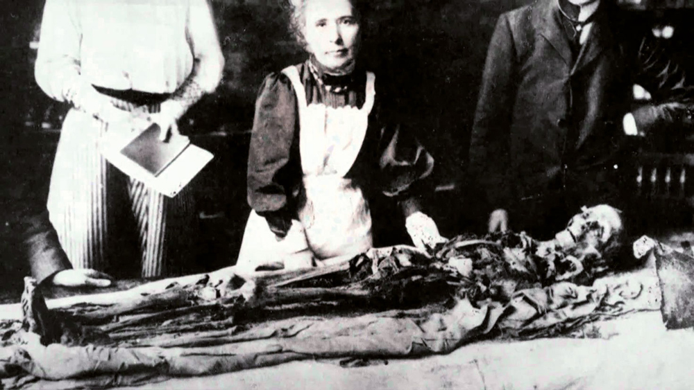 Margaret Murray egiptologoa, momiari bendak kentzeko prozesua azaltzen 500 ikusleren aurrean, Manchesterren, 1908an.