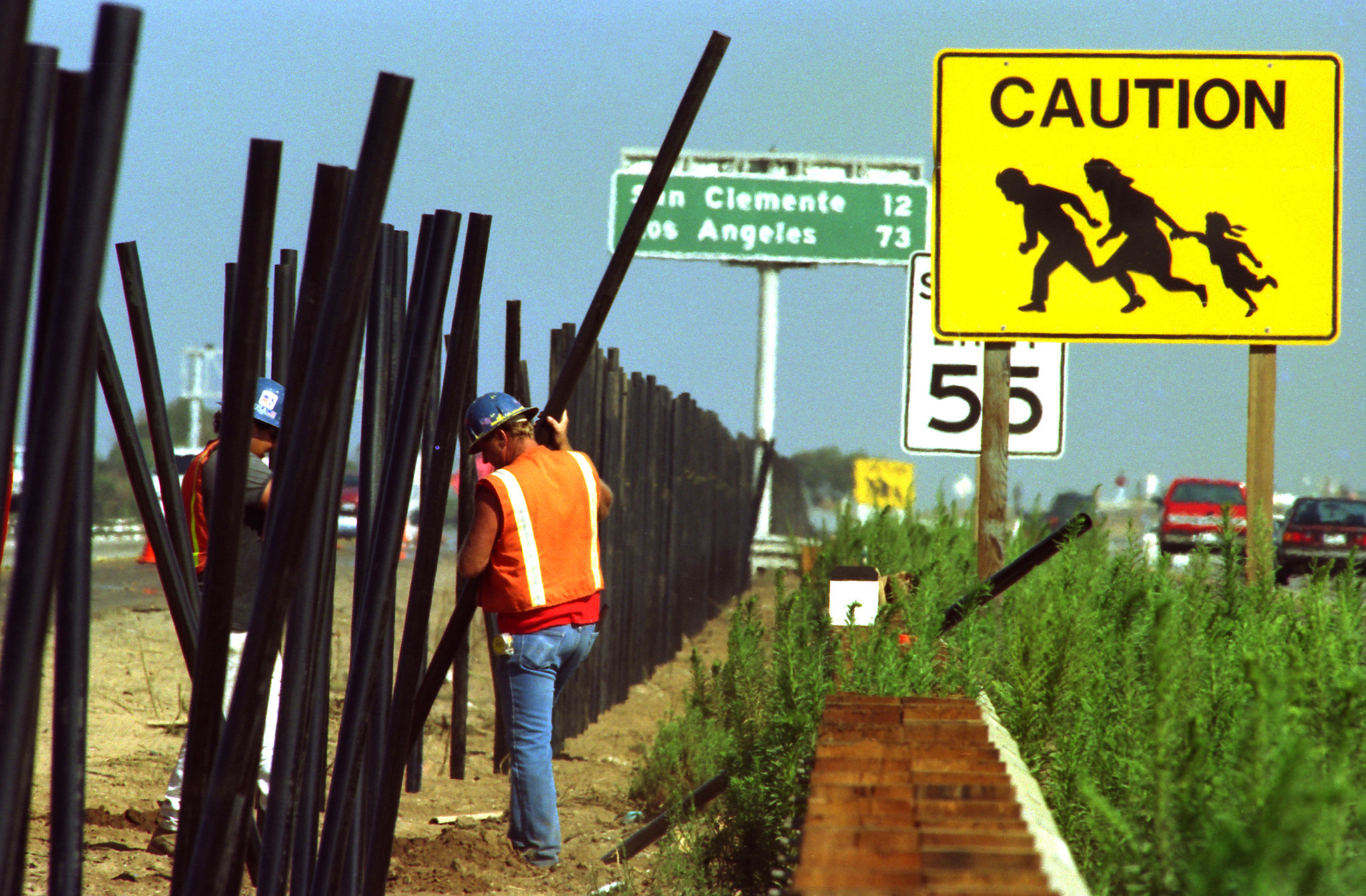 Don Bartlettik ‘Los Angeles Times’-en 1993an argitaratu zuen argazki hau: kontrata bateko obreroak Kaliforniako autopista zati horretan etorkinei pasabidea eragozteko hesia ari ziren eraikitzen, ondoan zeukatela aurreko urteetan alderdi haietan ezagunak z