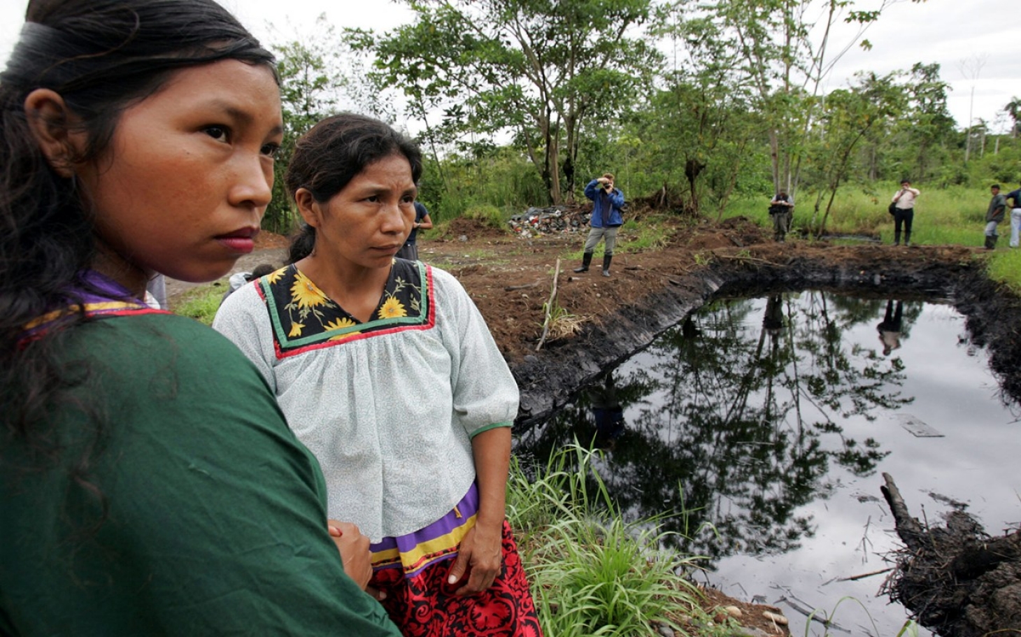 ‘Aljazeera’-k zabaldutako argazkian, Sucumbios probintziako herritar batzuk 
Texaco-Chevronek petrolioz eta hura lurpetik erauzteko toxikoz kutsatutako aintzira baten ondoan. Amazonian multinazionalek kaltetutako herritarrok kexu dira Rafael Correaren or